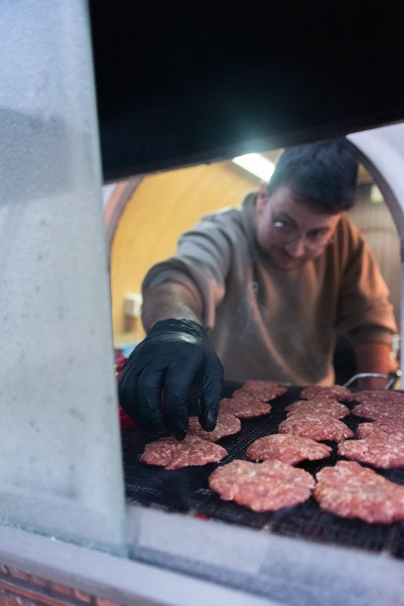 Am Grill im Truck werden rohe Köfte auf den Rost gelegt