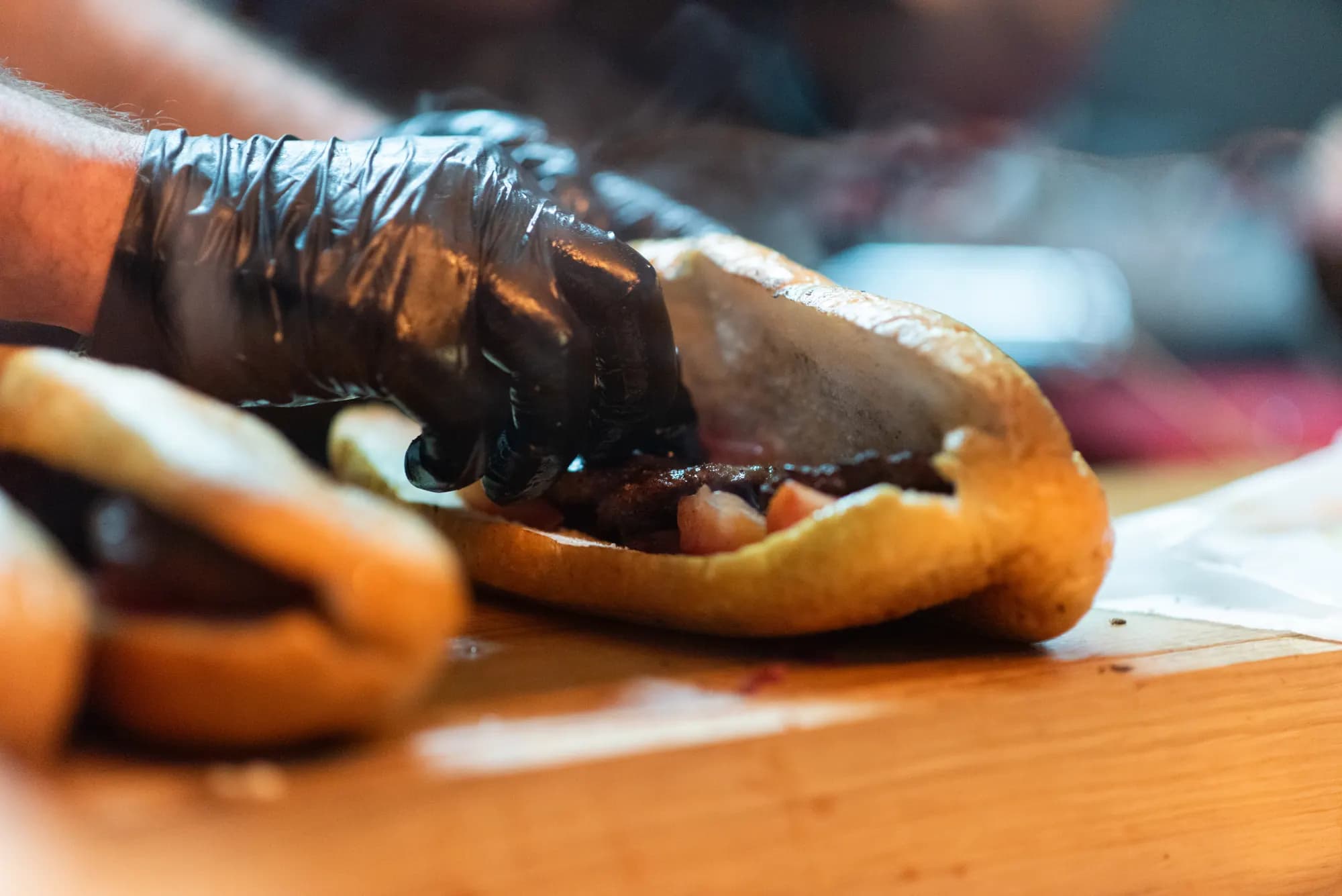 Mit Handschuhen werden die Köfte ins Brot gelegt